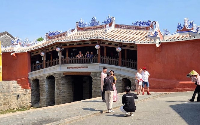 Chua Cau (the Bridge Pagoda) in Hoi An is one of Vietnams three most beautiful tile-roofed bridges. IN PHOTO: Visitors take commemorative photos after the pagodas restoration. Photo: V.T.L.