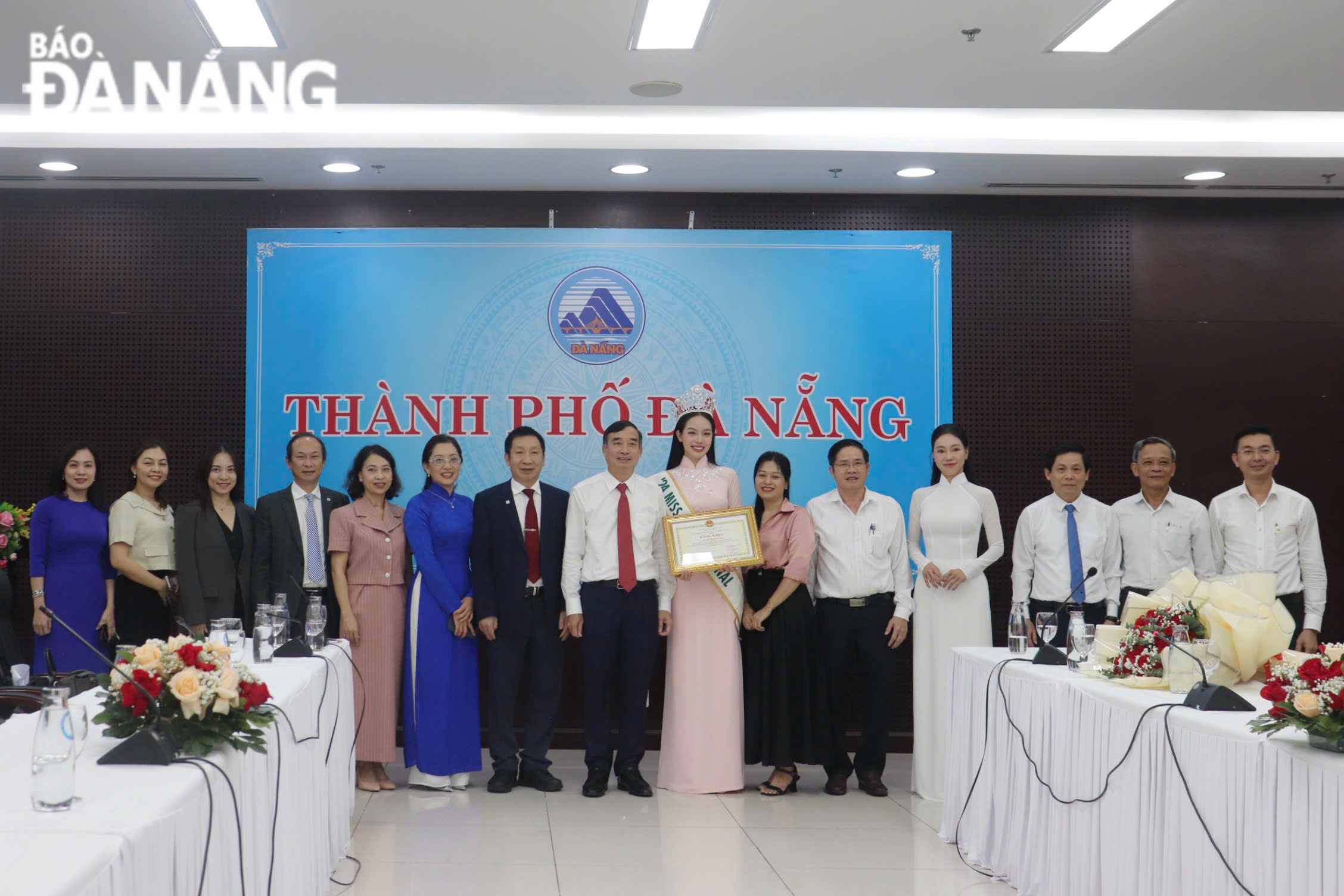 Miss International Huynh Thi Thanh Thuy posing for a souvenir photo with leaders of Da Nang departments and agencies. PHOTO: KHANH NGAN