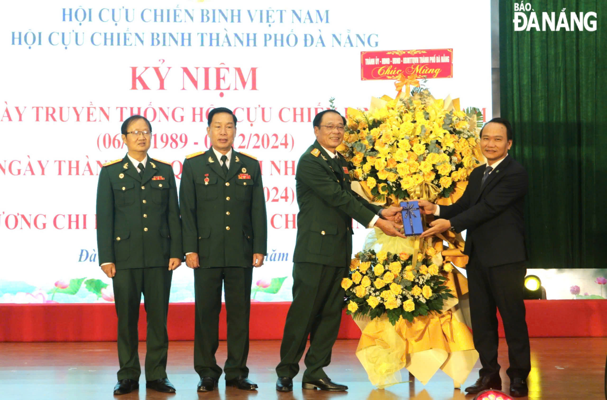 Phó Bí thư Thường trực Thành ủy Nguyễn Đình Vĩnh (bên phải), tặng hoa chúc mừng Hội Cựu chiến binh thành phố. Ảnh: N.Q