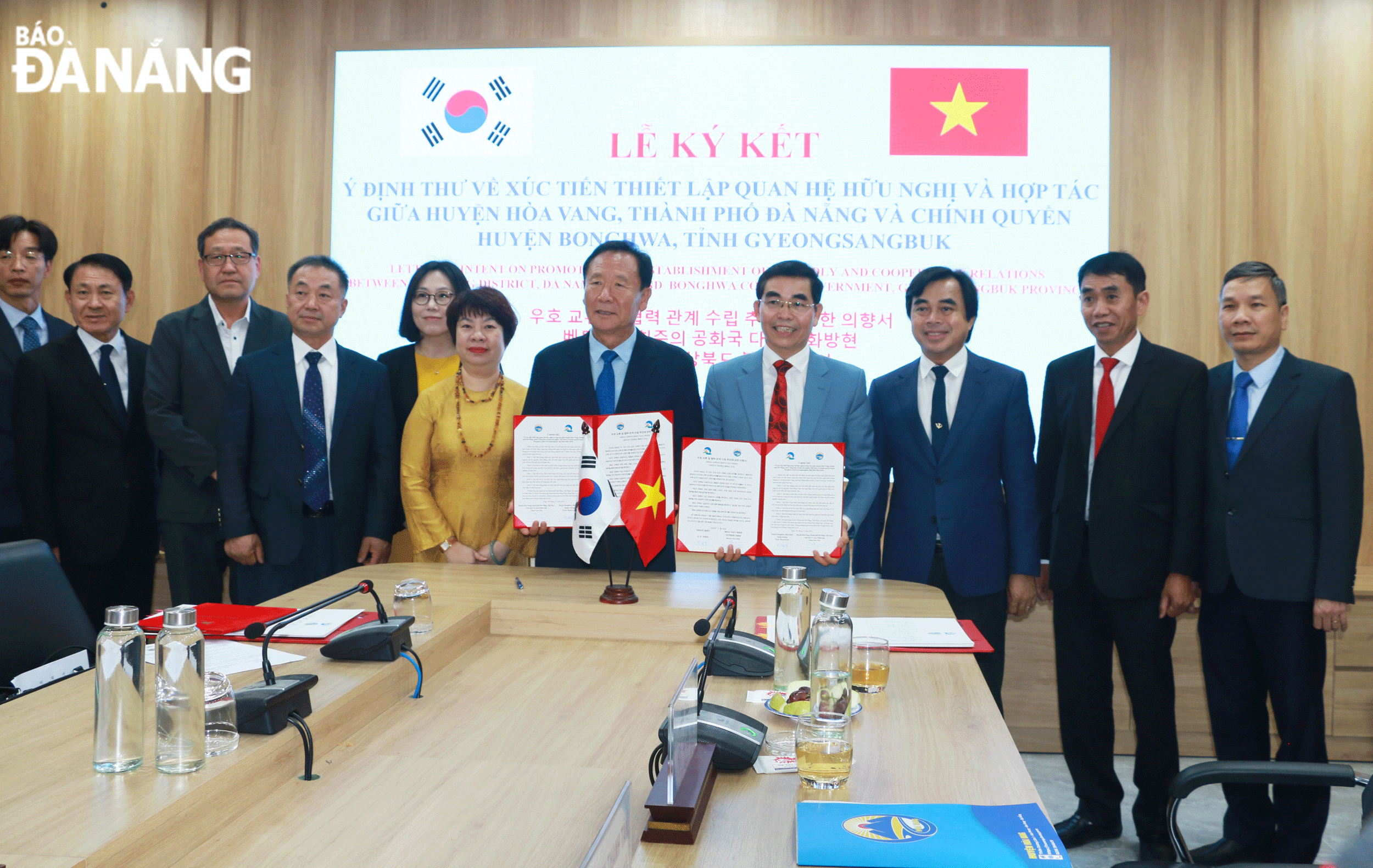 Chairman of the People's Committee of Hoa Vang District Phan Van Ton (4th, right) and Bonghwa District Chief Park Hyun Gook (5th, left) signed a letter of intent on promoting the establishment of friendly and cooperative relations between the two localities. Photo: T.P