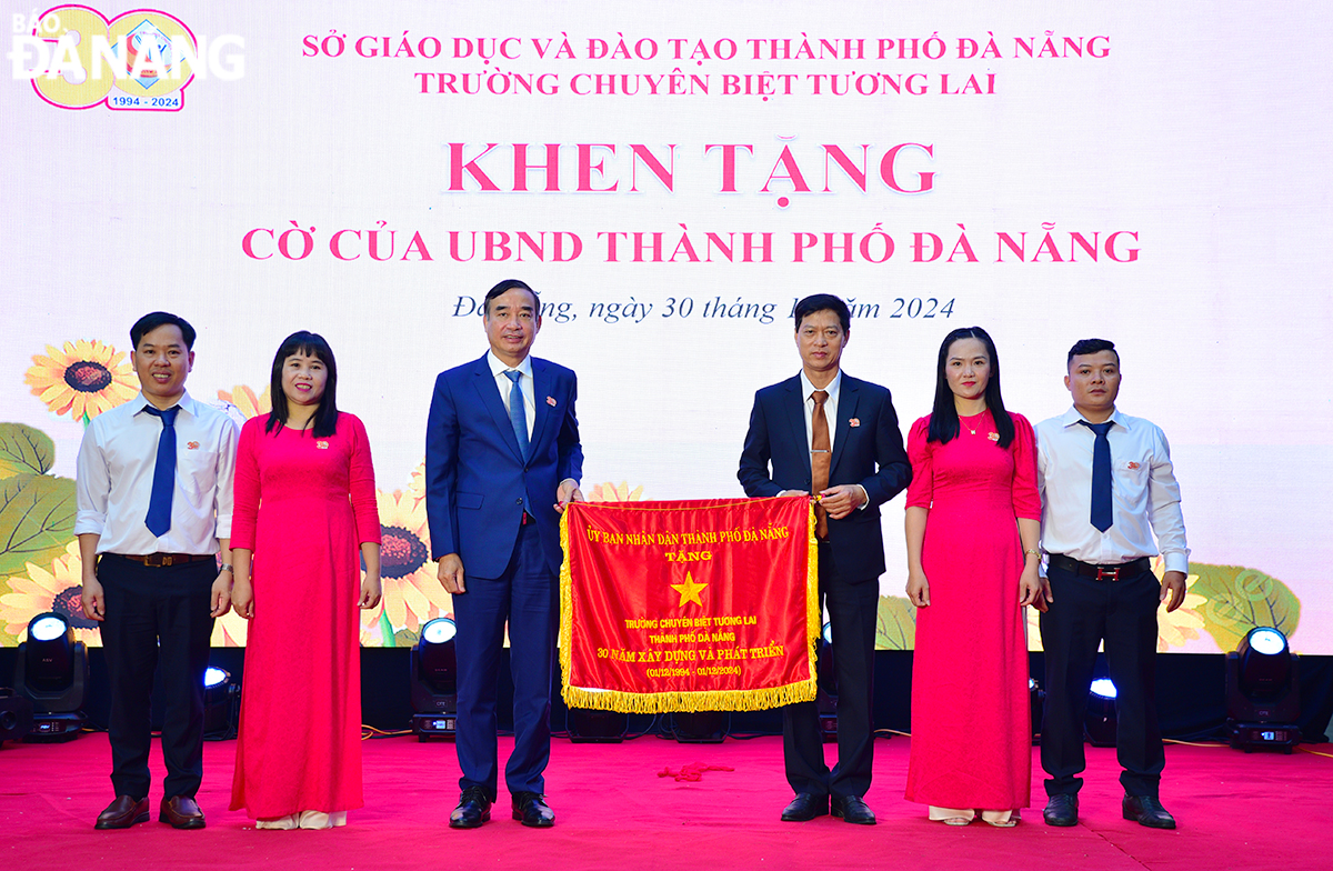 Chairman of the Da Nang People's Committee Le Trung Chinh presented the Emulation Flag to the Tuong Lai Specialised School. Photo: X.D