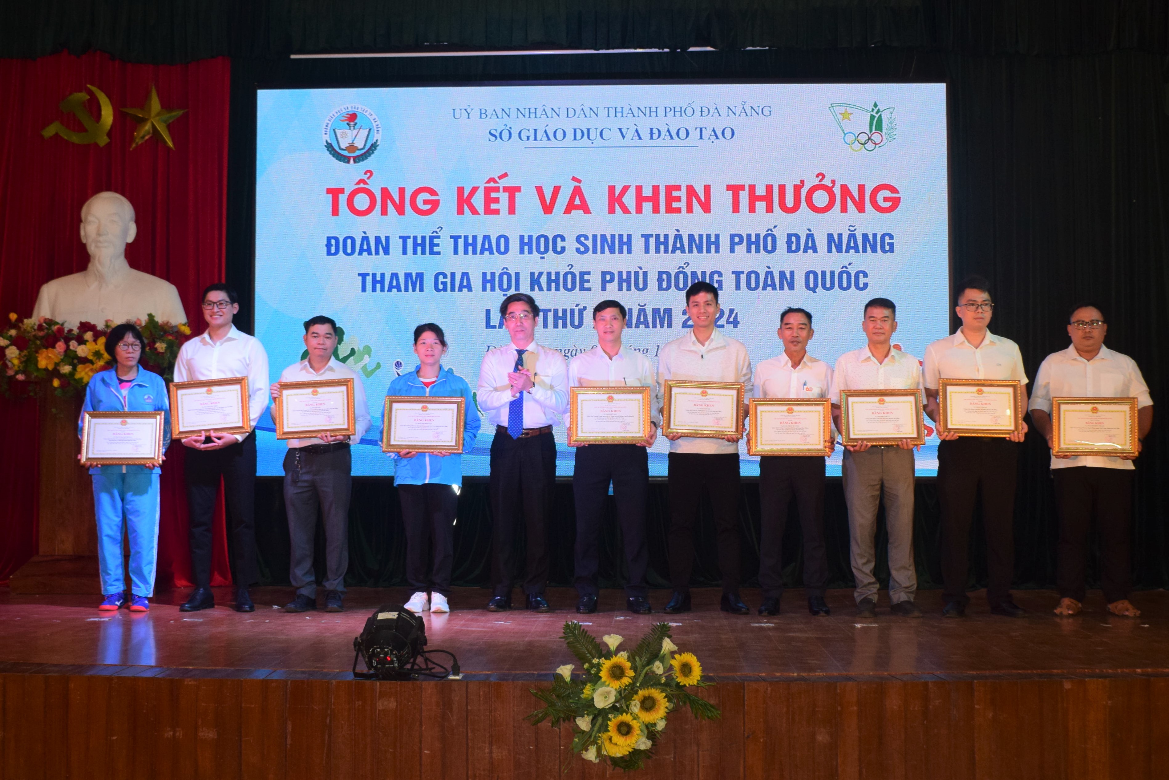 Vice Chairman of the Da Nang People’s Committee Tran Chi Cuong presenting Certificates of Merit to officials and coaches of schools. Photo: PHI NONG