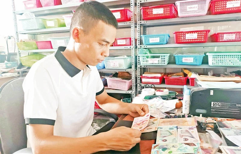 Mr. Tran Van Nam checks the bills.