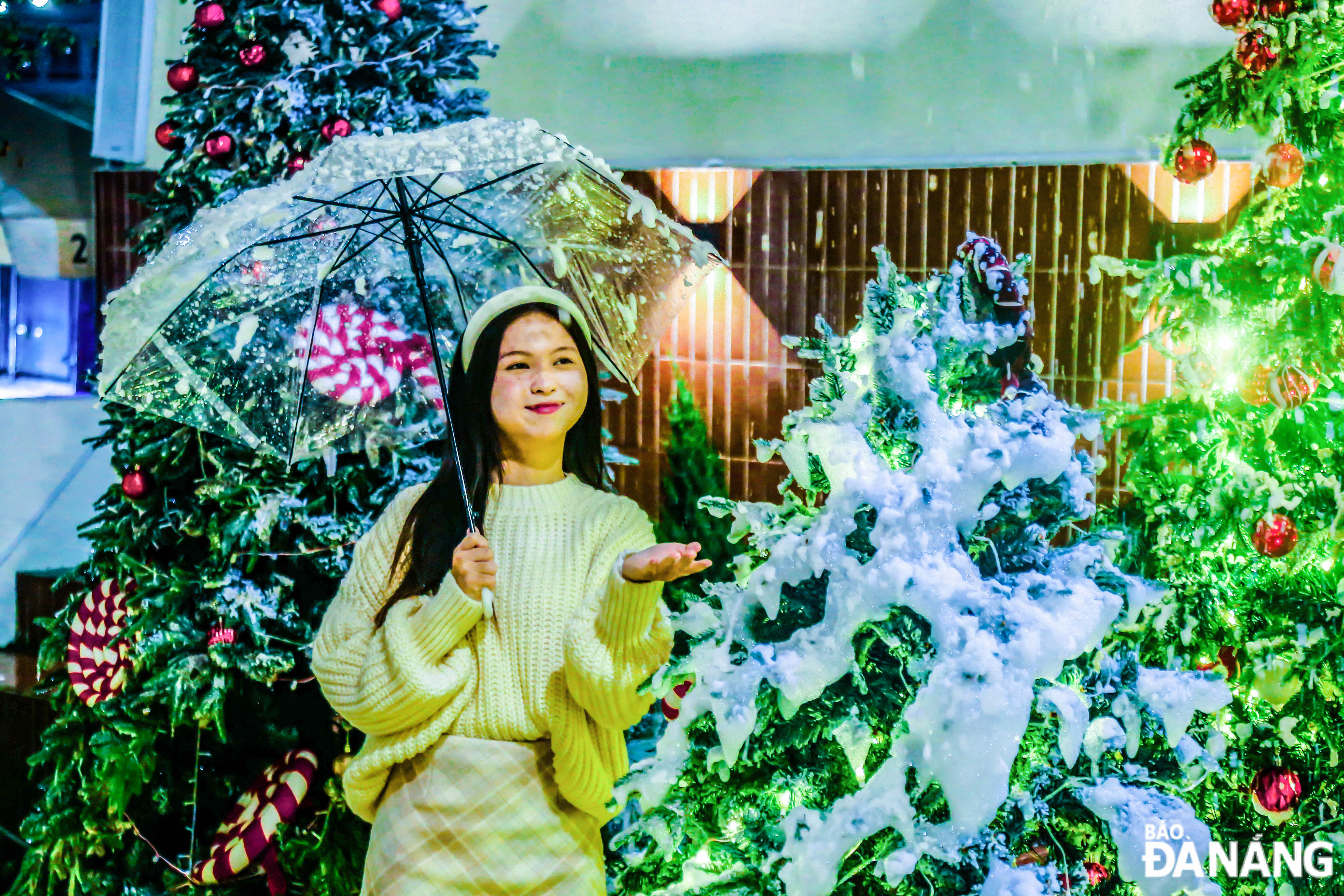 A girl posing for a photo with the Christmas tree at the coffee shop on Nguyen Tri Phuong Street.