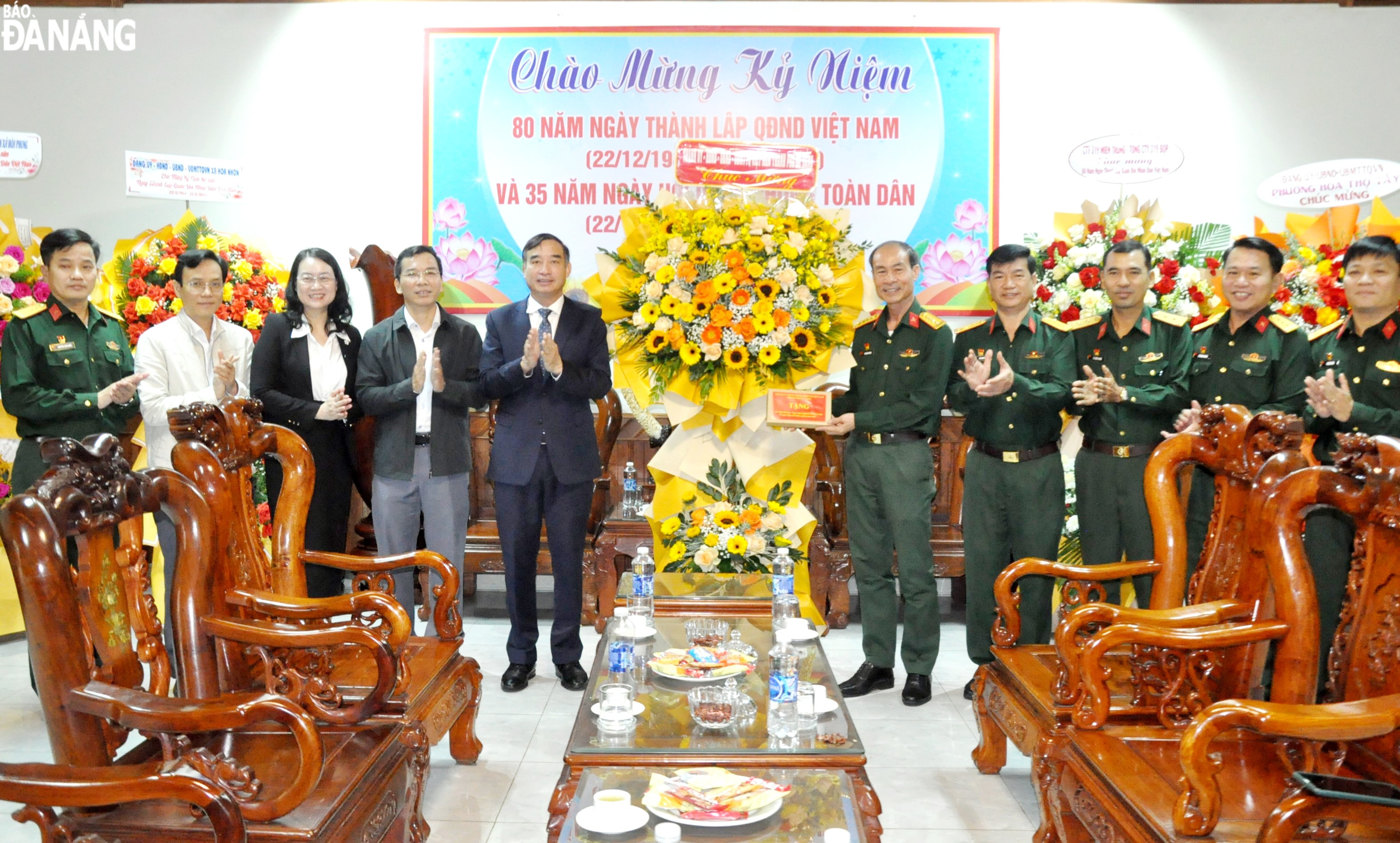 Chủ tịch UBND thành phố Lê Trung Chinh (thứ 5, bên trái sang) tặng hoa chúc mừng Trường Quân sự Quân khu 5. Ảnh: LÊ HÙNG