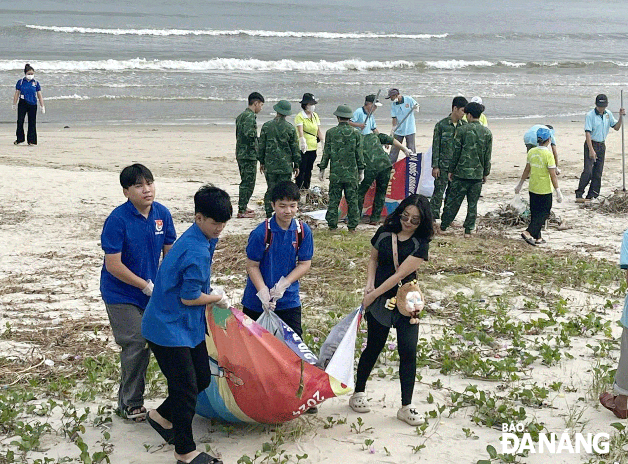 Thu dọn rác trên bãi biển Nguyễn Tất Thành. Ảnh: HOÀNG HIỆP	