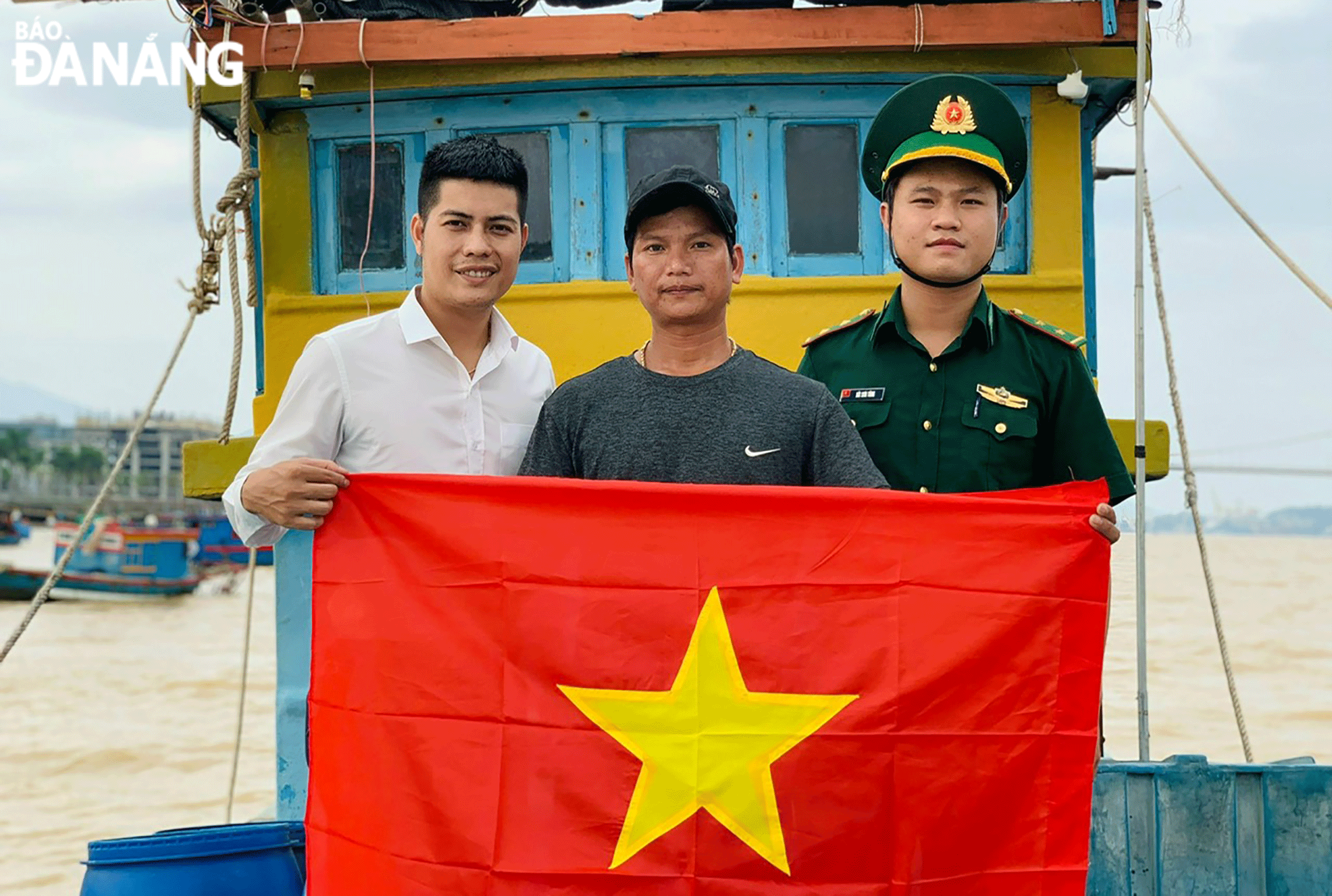 Border guards present a national flag to a fisherman in Da Nang. Photo: HUYNH VU