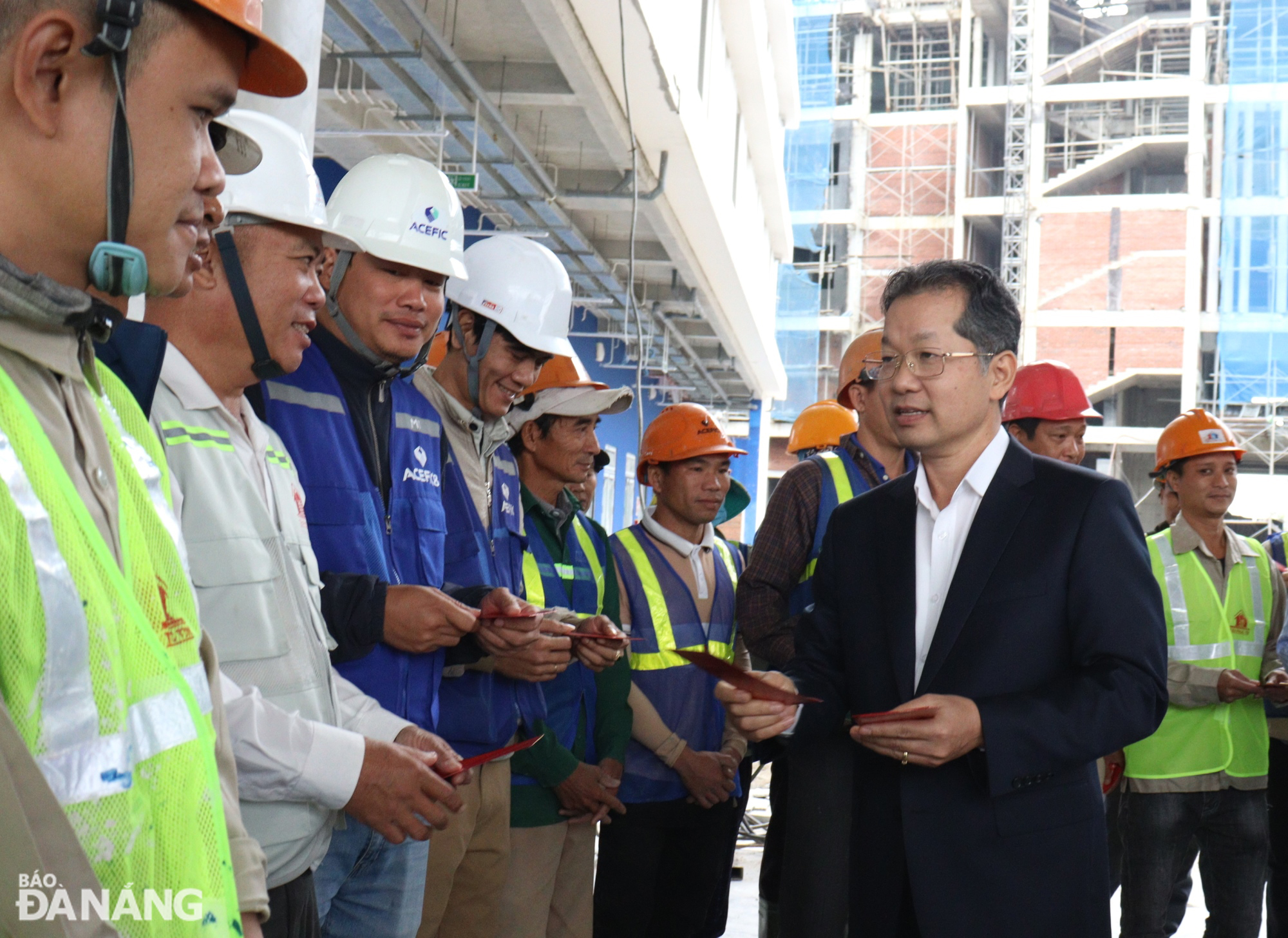 Secretary of the Da Nang Party Committee Nguyen Van Quang giving lucky money to construction workers at the Hy Vong (Hope) School (phase 1). Photo: HOANG HIEP