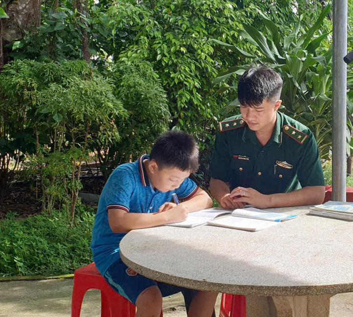 Thượng úy Nguyễn Đăng Tuấn dạy học cho trẻ em có hoàn cảnh khó khăn.  Ảnh: DOÃN QUANG	