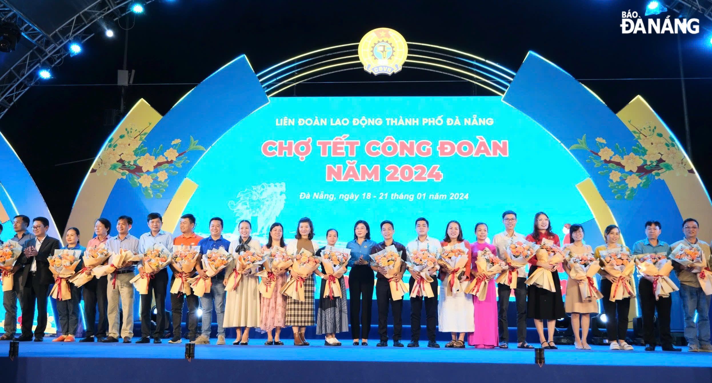 Chairwoman of the Da Nang Labour Federation Phan Thi Thuy Linh (11th, right) presenting flowers to partners participating in the 2024 Trade Union Tet Market. Photo: X.H