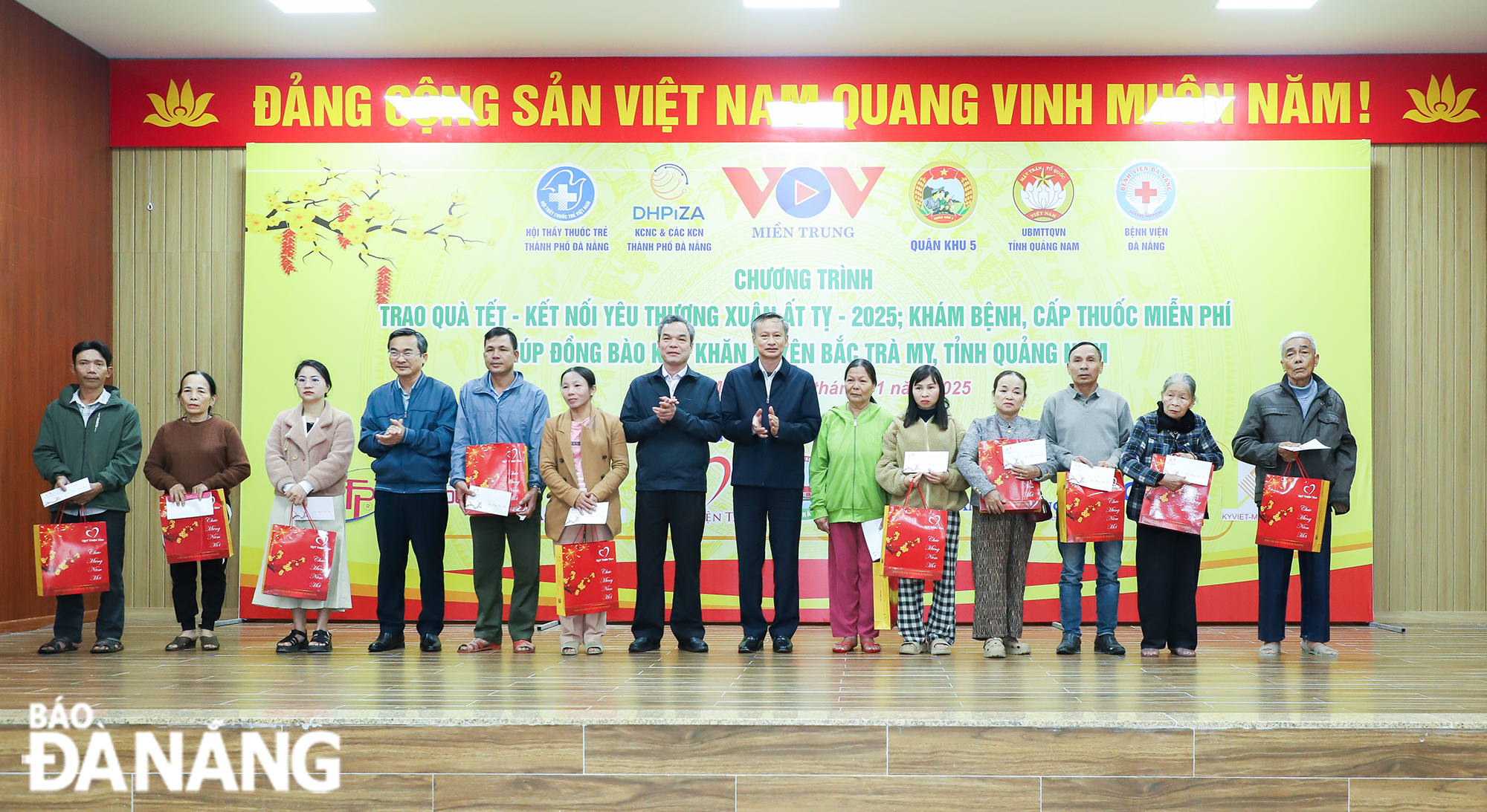 Head of Da Nang Party Committee's Publicity and Training Department Doan Ngoc Hung Anh (7th from right) presenting gifts to poor families. Photo: NGOC PHU