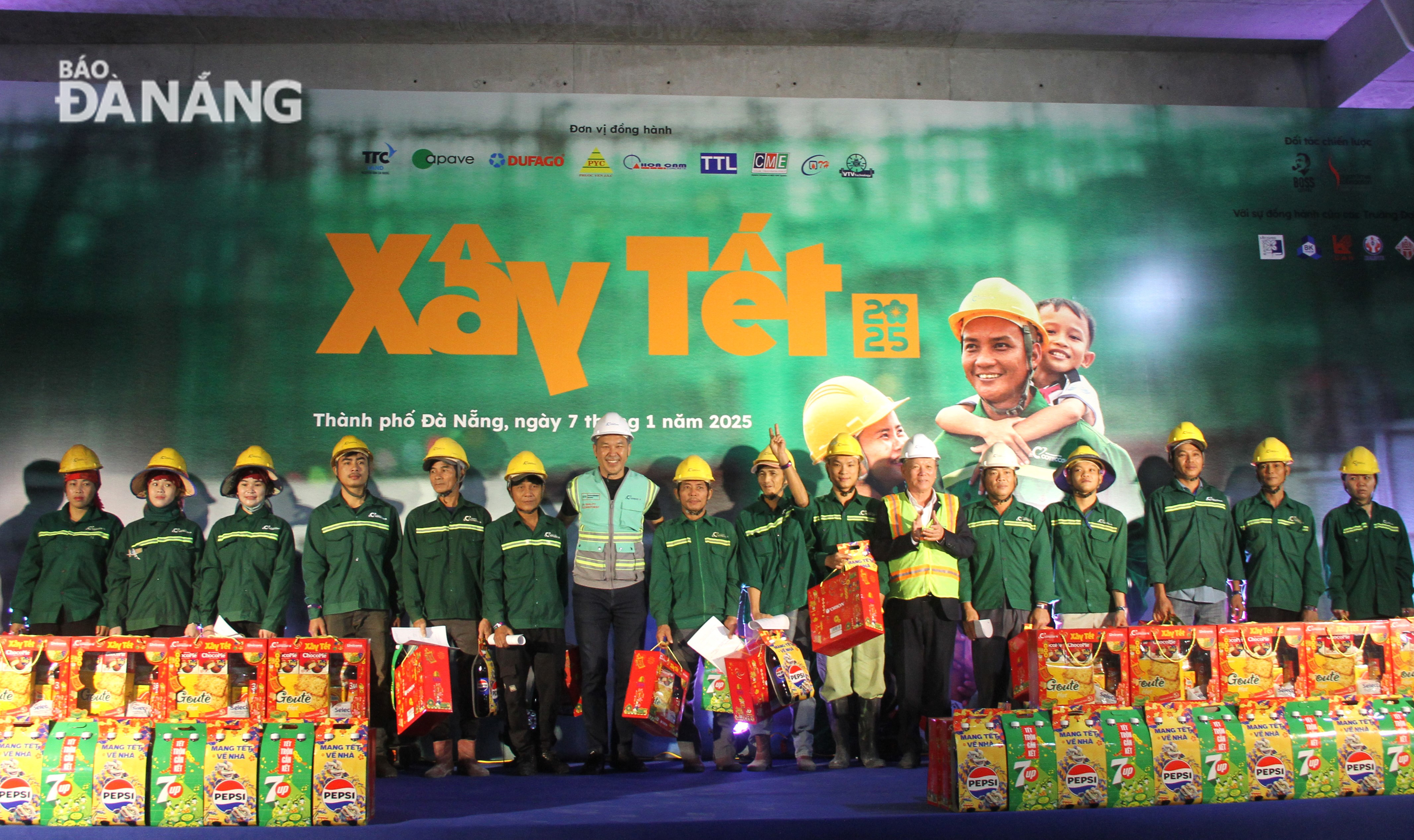 Representatives of the Nhan Dan (People) Newspaper, Coteccons Construction JSC and city leaders giving Tet gifts to construction workers. Photo: L.P