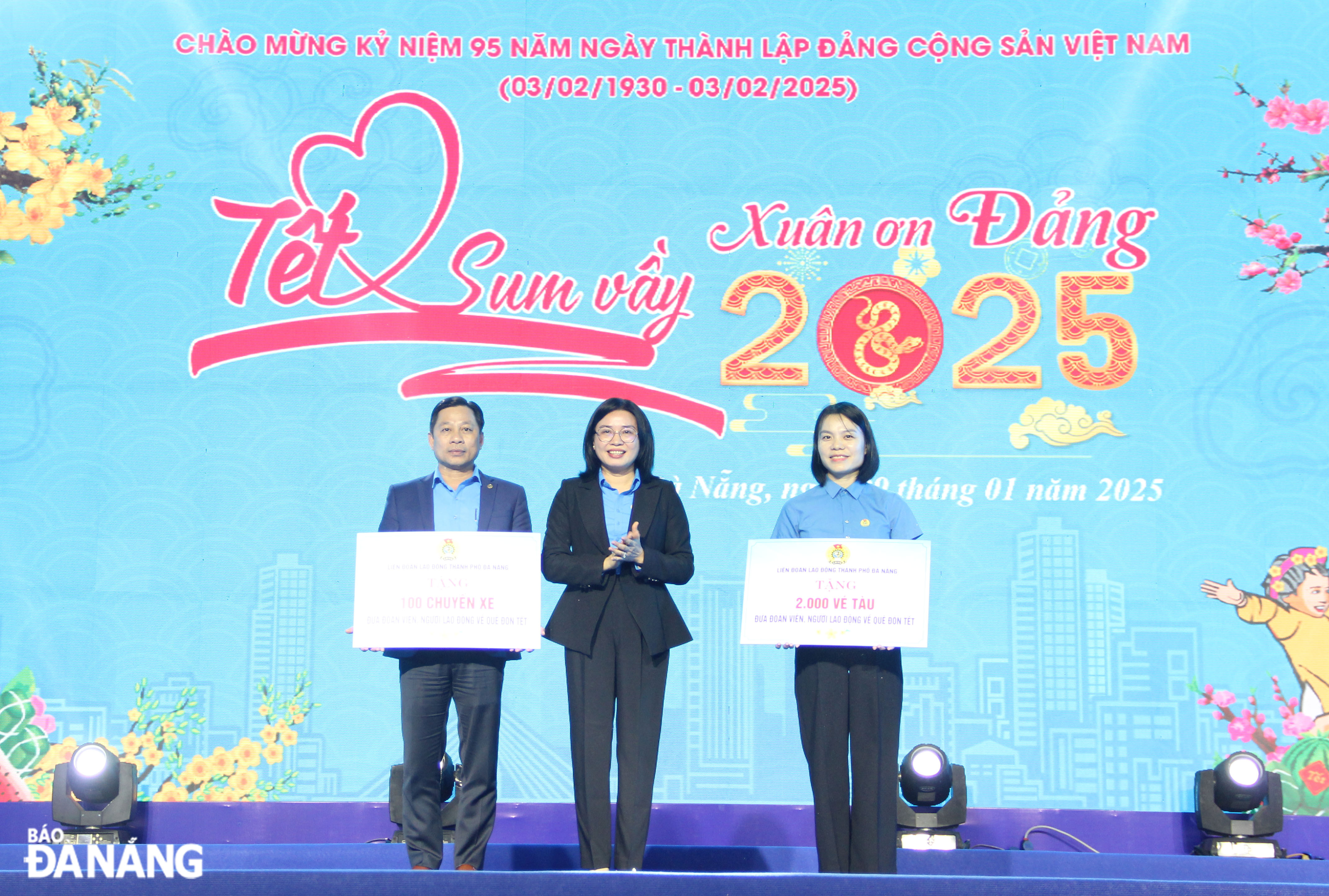 Chairwoman of the Da Nang Labour Federation Phan Thi Thuy Linh (middle) presents symbolic boards of donations about train and bus tickets for the programme 