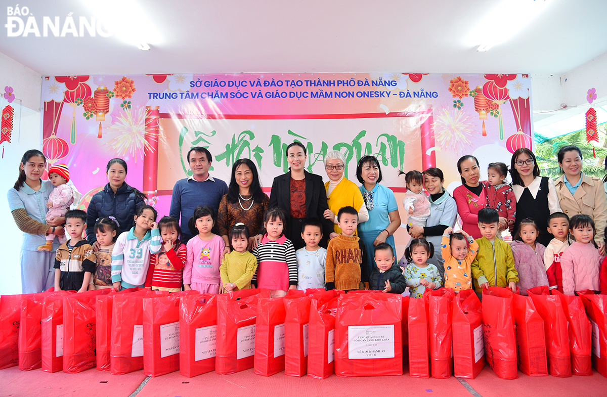 Vice Chairwoman of the Da Nang People's Committee Nguyen Thi Anh Thi giving gifts to families of workers in especially difficult circumstances whose children are studying at the centre. Photo: XUAN DUNG