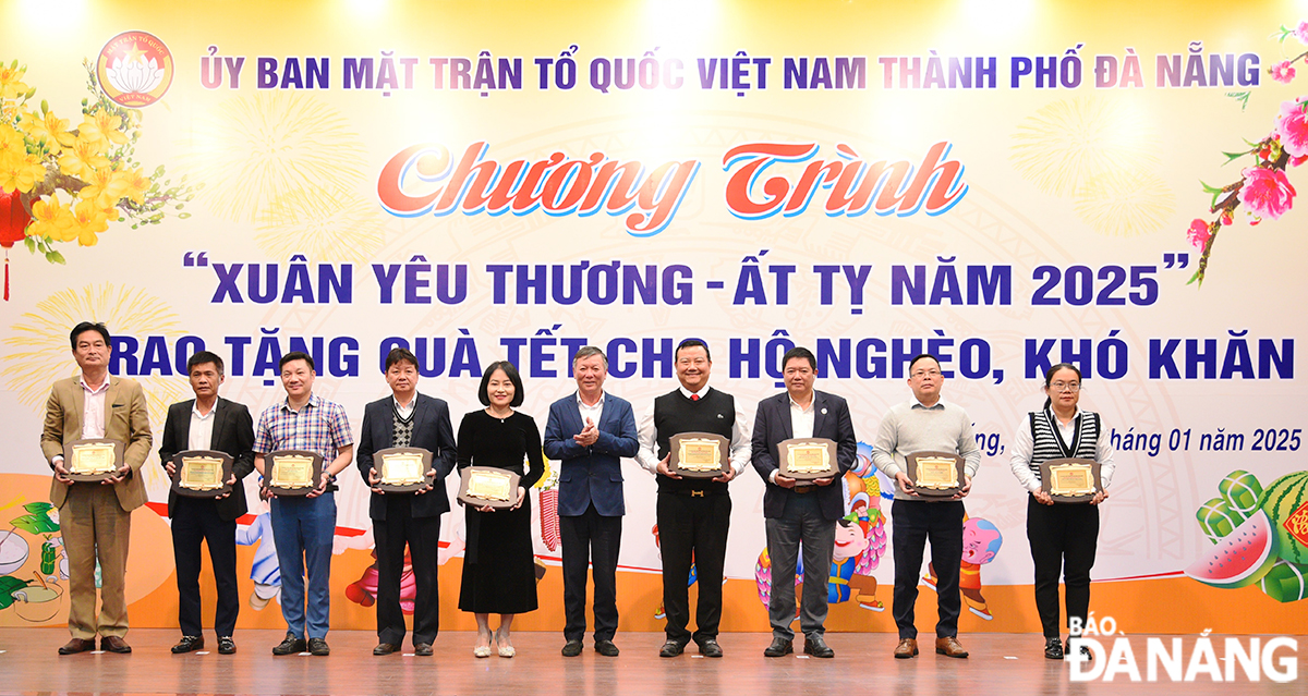 Chủ tịch Ủy ban MTTQ Việt Nam thành phố Lê Văn Trung (ở giữa) trao biểu trưng ghi nhận tấm lòng vàng cho 10 đơn vị ủng hộ Quỹ 