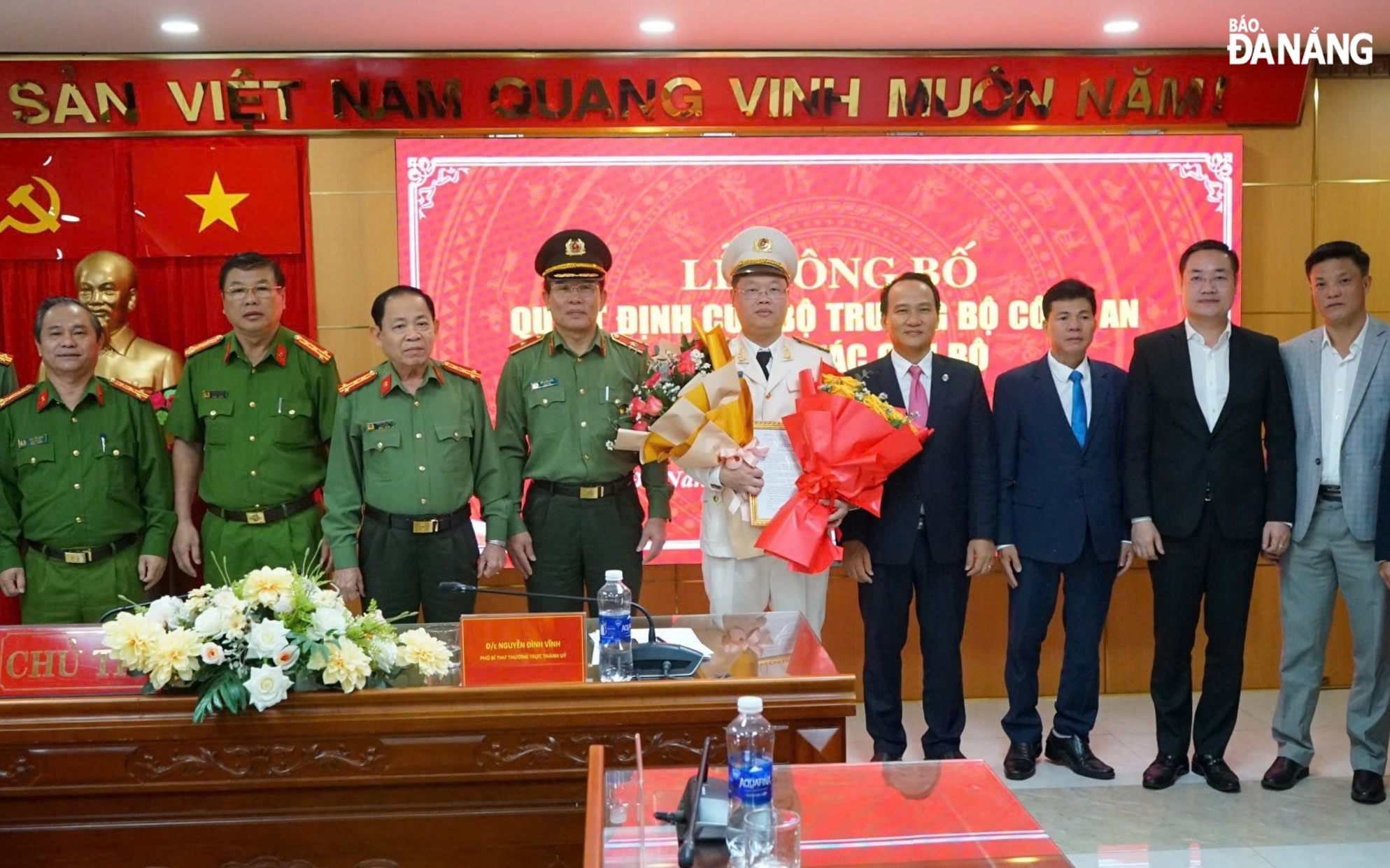 Phó Bí thư Thường trực Thành ủy Nguyễn Đình Vĩnh (thứ 4, bên trái sang) tặng hoa chúc mừng Trung tá Nguyễn Kim Trung. Ảnh: LÊ HÙNG