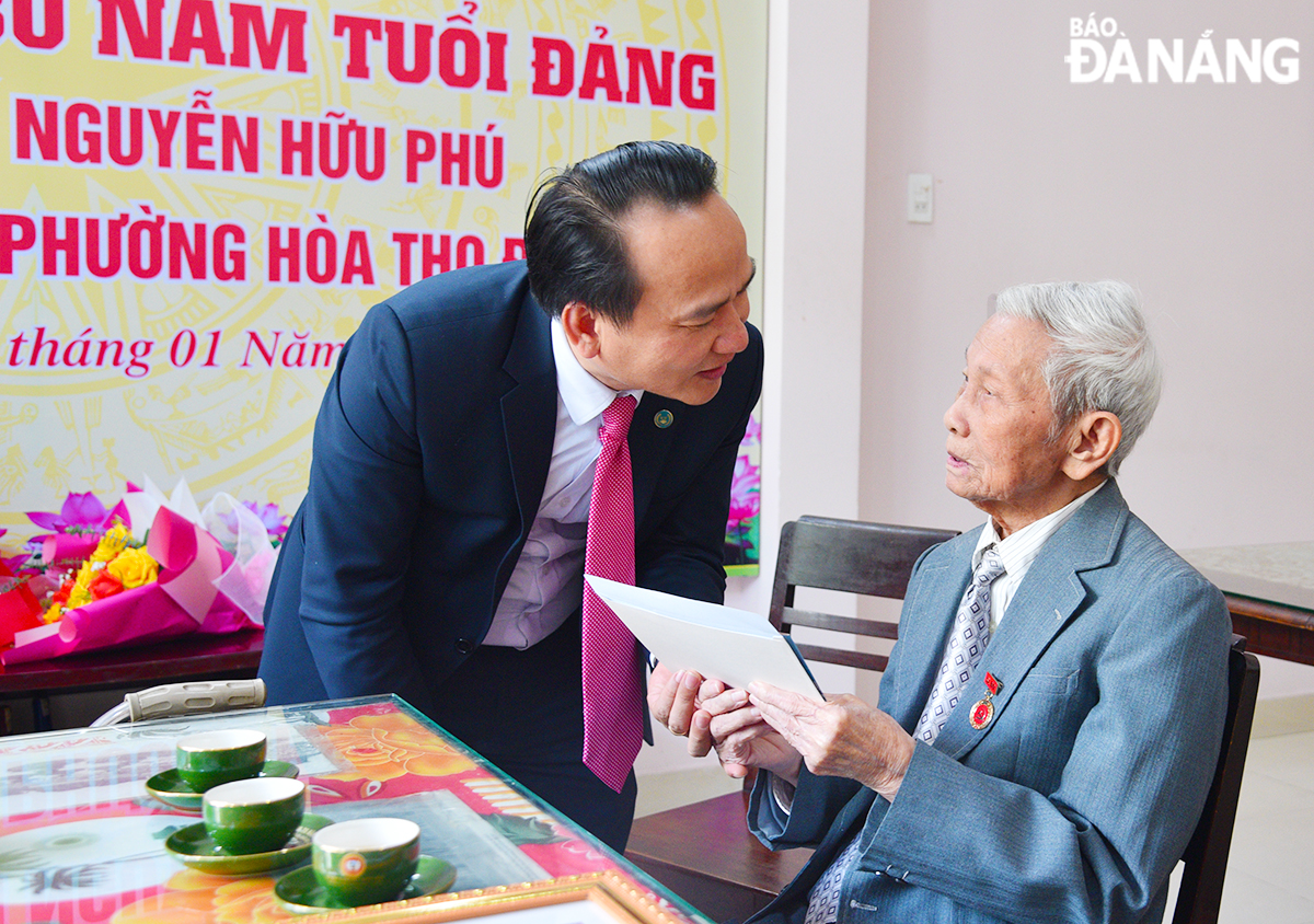 Phó Bí thư Thường trực Thành ủy Nguyễn Đình Vĩnh thăm hỏi, chúc mừng năm mới đến ông Nguyễn Hữu Phú. Ảnh: T.PHƯƠNG