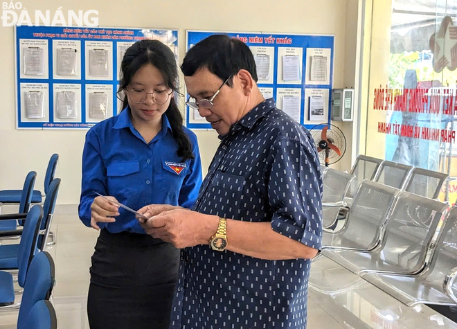 Đoàn viên thanh niên quận Thanh Khê hướng dẫn người dân sử dụng dịch vụ công trực tuyến. Ảnh: M.QUẾ