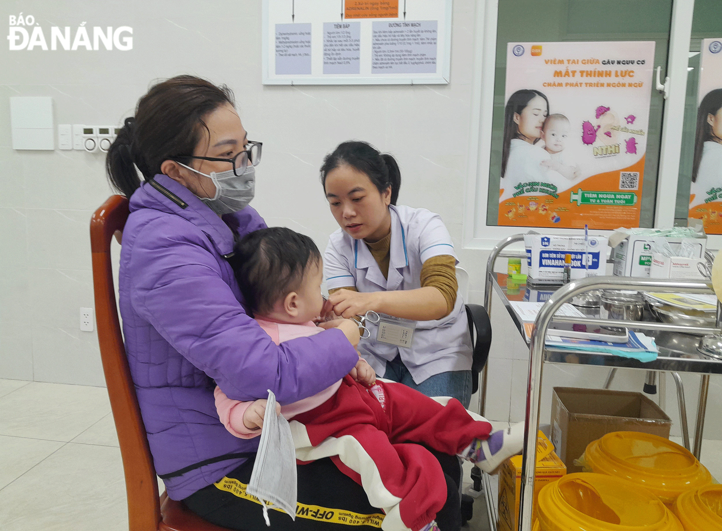 Nhân viên Phòng khám đa khoa (CDC thành phố) tiêm vắc-xin phòng cúm mùa cho người dân. (Ảnh chụp sáng 10-2) Ảnh: LÊ HÙNG