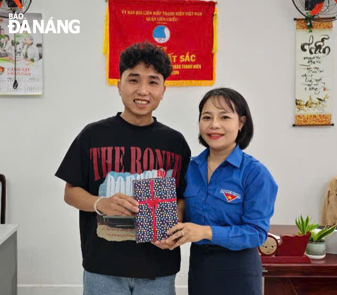 Bùi Xuân Lượng (trái) nhận quà lưu niệm từ Bí thư Đoàn phường Hòa Hiệp Bắc - Huỳnh Võ Hà Lê 