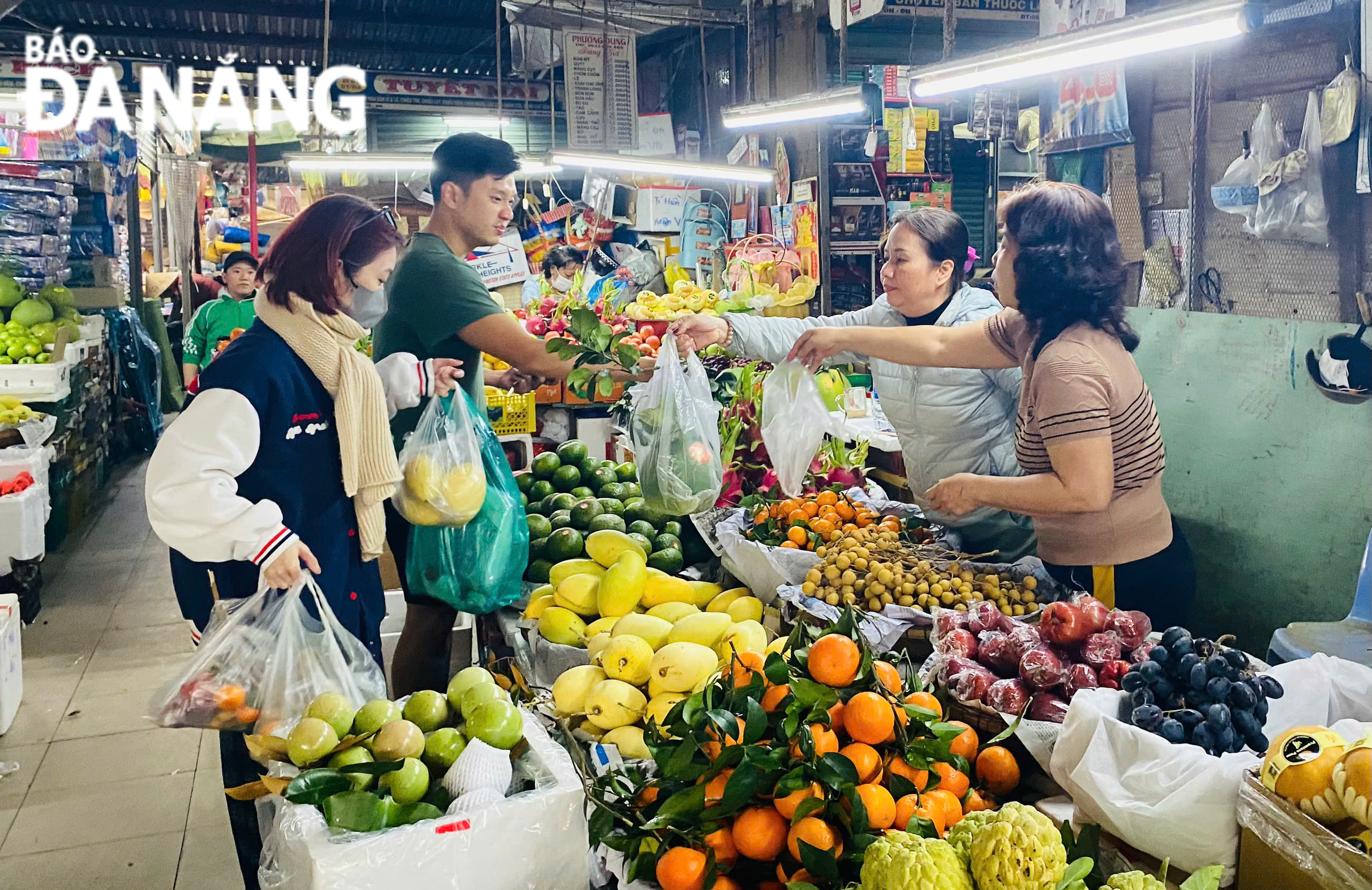 người mua hàng đến chợ lựa chọn những bó hoa đẹp nhất và trái cây ngũ quả để dâng lên bàn thờ. 