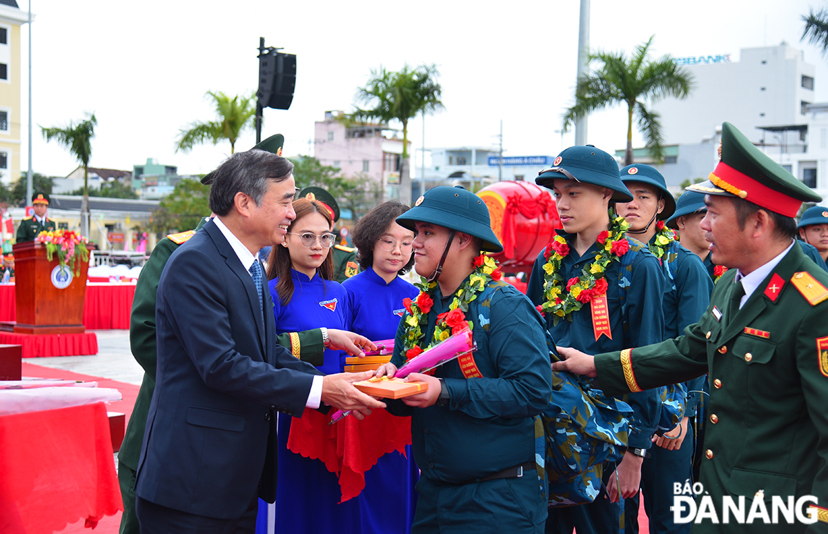 Chủ tịch UBND thành phố Lê Trung Chinh tặng hoa và quà cho tân binh quận Hải Châu lên đường nhập ngũ. Ảnh: XUÂN DŨNG
