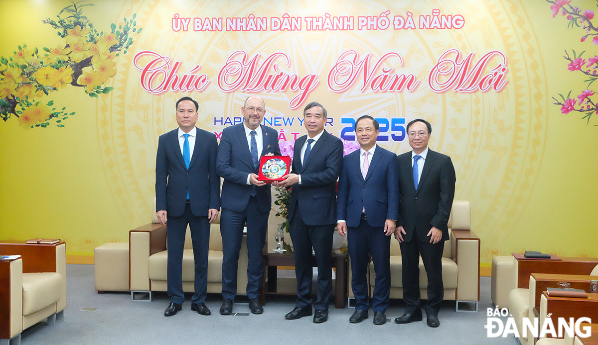 Chủ tịch UBND thành phố Lê Trung Chinh (thứ 3, từ phải sang) tặng quà lưu niệm đến Đại sứ Thụy Sĩ tại Việt Nam Thomas Gass (thứ 2, từ trái sang). Ảnh: T.PHƯƠNG