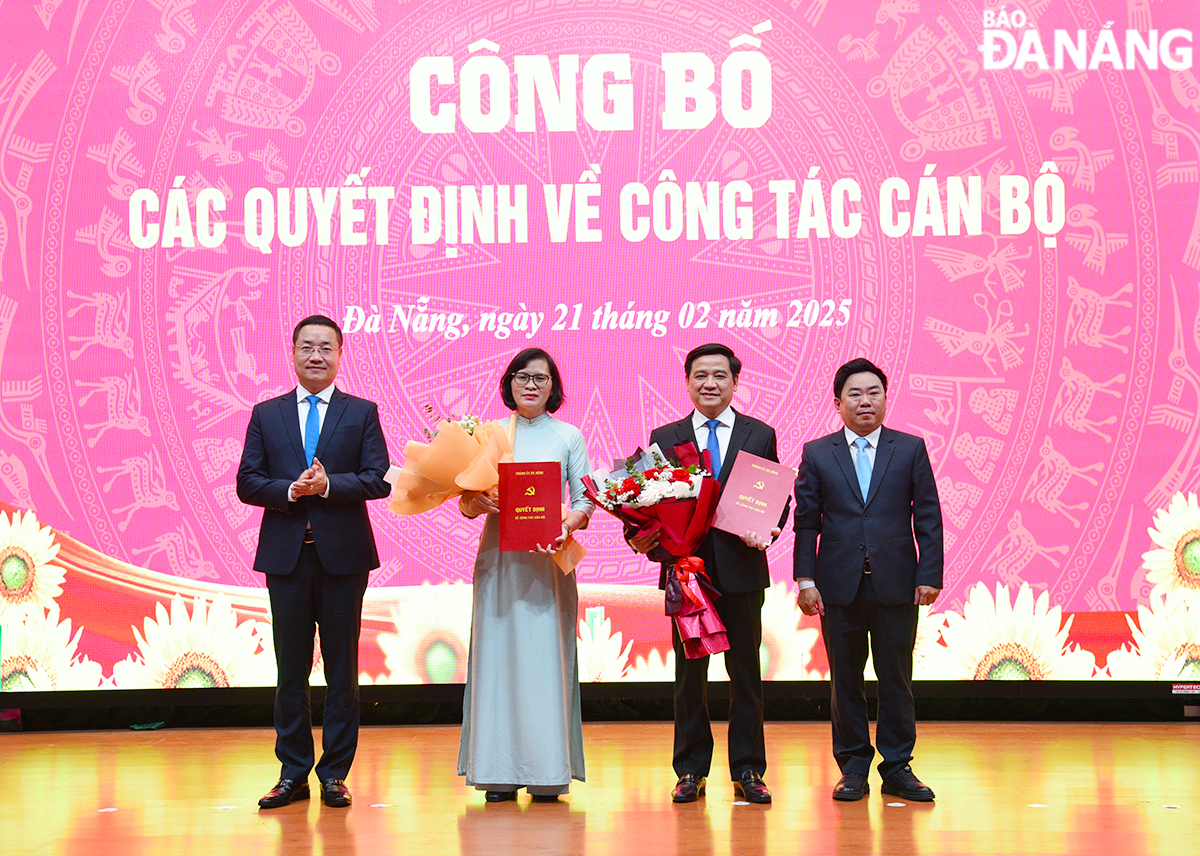 Phó Trưởng ban Tổ chức Thành ủy Nguyễn Lê Mậu Cường (bên trái) và Phó Giám đốc Sở Nội vụ Trần Trung Sơn (bên phải) trao quyết định và tặng hoa chúc mừng ông Hồ Thuyên và bà Trần Tường Vân. Ảnh: T.PHƯƠNG