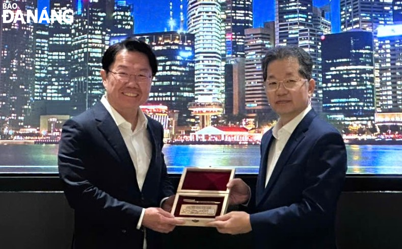 Bí thư Thành ủy Nguyễn Văn Quảng (bên phải) và đại diện Cơ quan tiền tệ Singapore (MAS). Ảnh: ĐOÀN CÔNG TÁC