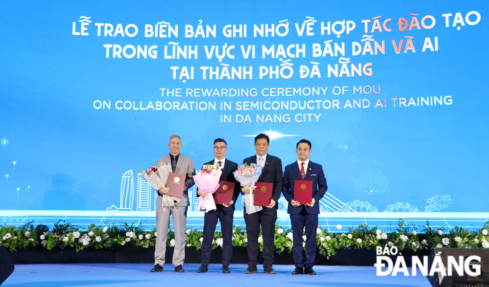  Representatives of the DSAC (first, right) exchange a four-party memorandum of understanding with partners on training in semiconductor microchips and AI within the framework of the The City Partnership Forum - Da Nang 2025 event. Photo: MAI QUE