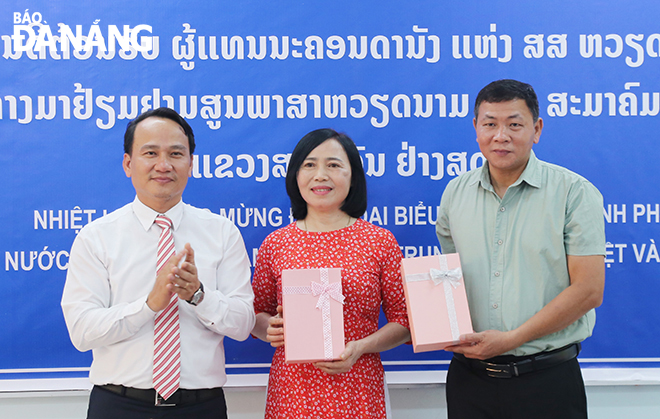 Standing Deputy Secretary of the Da Nang Party Committee Nguyen Dinh Vinh (first left) gave gifts to two teachers sent by the city to teach at the Vietnamese Language Centre in Salavan Province. Photo: DAC MANH