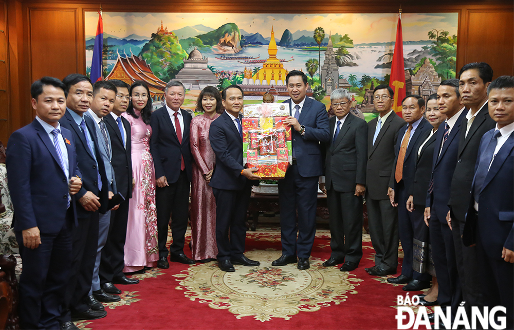 Phó Bí thư Thường trực Thành ủy Nguyễn Đình Vĩnh (thứ 8 từ trái qua) tặng quà lãnh đạo tỉnh Champasak nhân dịp Tết Bunpimay 2025 (Phật lịch 2568). Ảnh: ĐẮC MẠNH