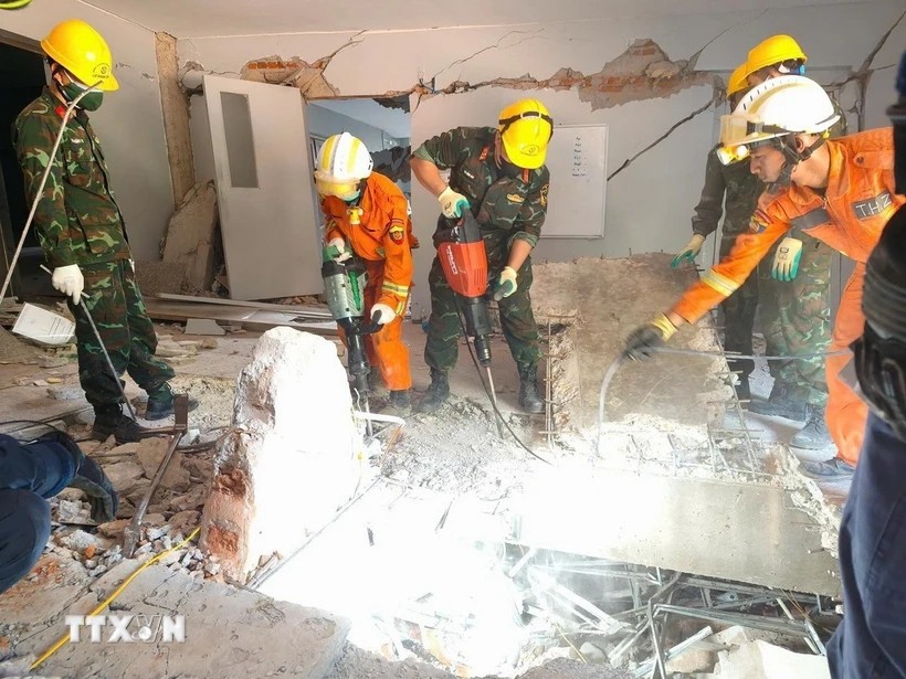 Đội công binh của đoàn QĐND Việt Nam và lực lượng cứu hộ của Myanmar, UAE đục bêtông để mở lối xuống tiếp cận vị trí các nạn nhân bị vùi lấp. (Ảnh: TTXVN phát)