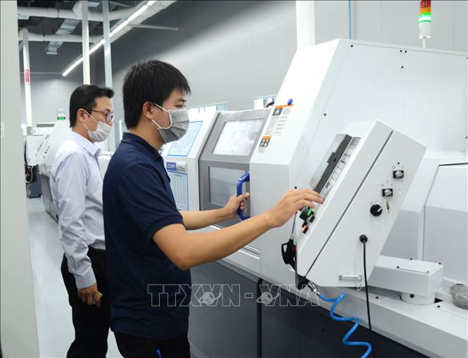 Công nhân vận hành máy sản xuất tại Công ty ICT Vina, Khu Công nghệ cao thành phố Đà Nẵng.  Ảnh minh họa: TTXVN