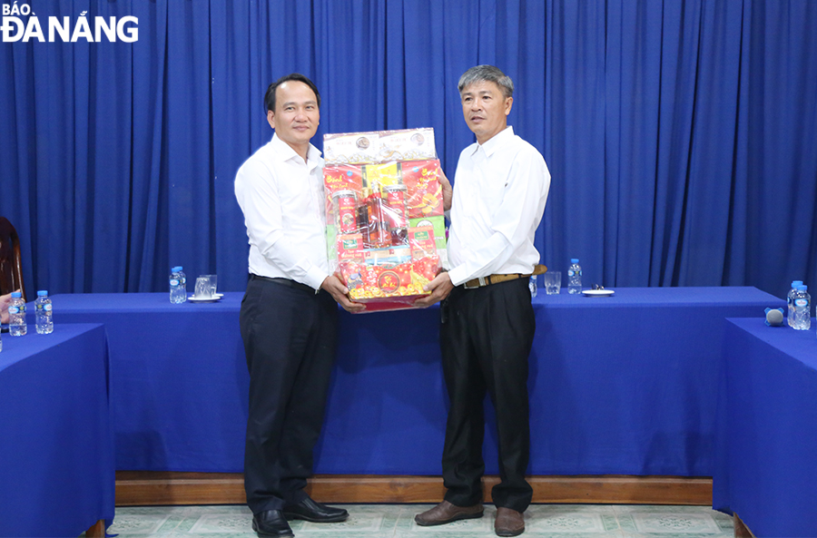 Phó Bí thư Thường trực Thành ủy Nguyễn Đình Vĩnh (bên trái) tặng quà Hội người Việt Nam tỉnh Attapeu. Ảnh: ĐẮC MẠNH 