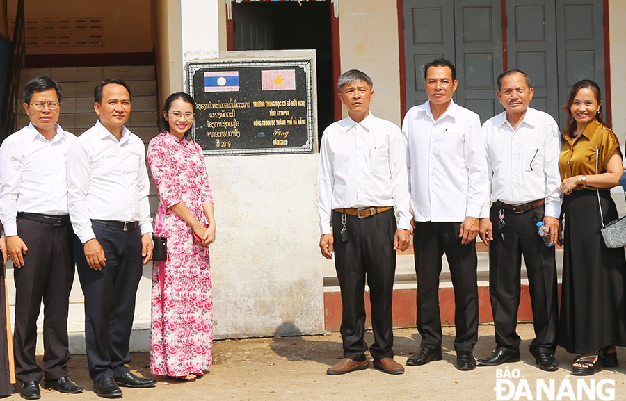 Phó Bí thư Thường trực Thành ủy Nguyễn Đình Vĩnh (thứ 2, bên trái qua) bên công trình trường Trung học Hữu nghị Lào - Việt tỉnh Attapeu. Ảnh: ĐẮC MẠNH 