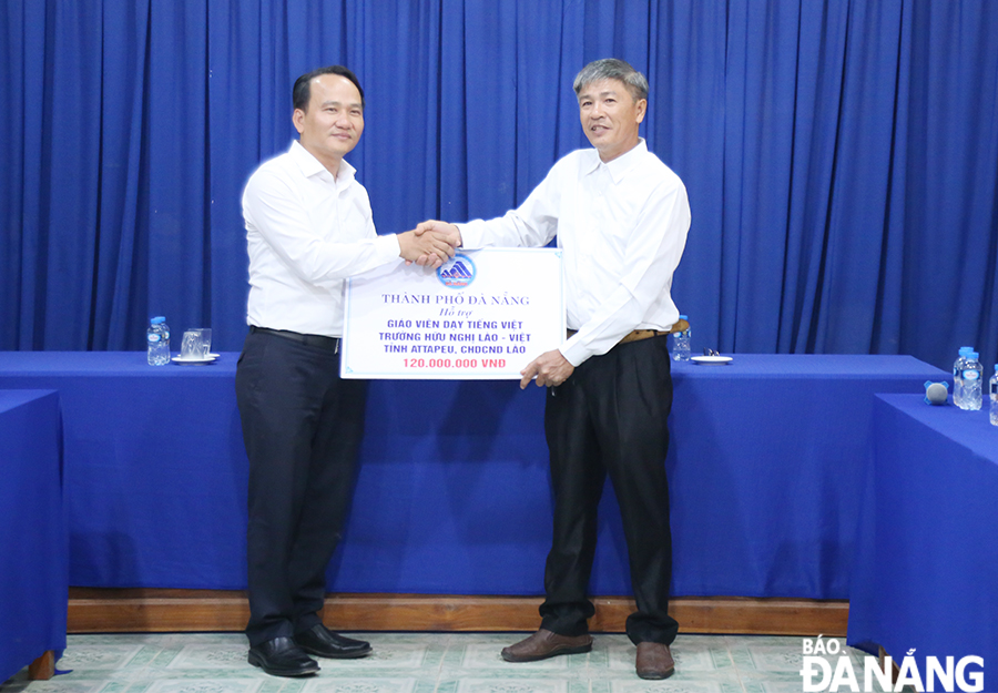 Permanent Deputy Secretary of the Da Nang Party Committee Nguyen Dinh Vinh (left) presented the Association of Vietnamese people in Attapeu Province with VND 120 million to support Vietnamese teachers there. Photo: DAC MANH