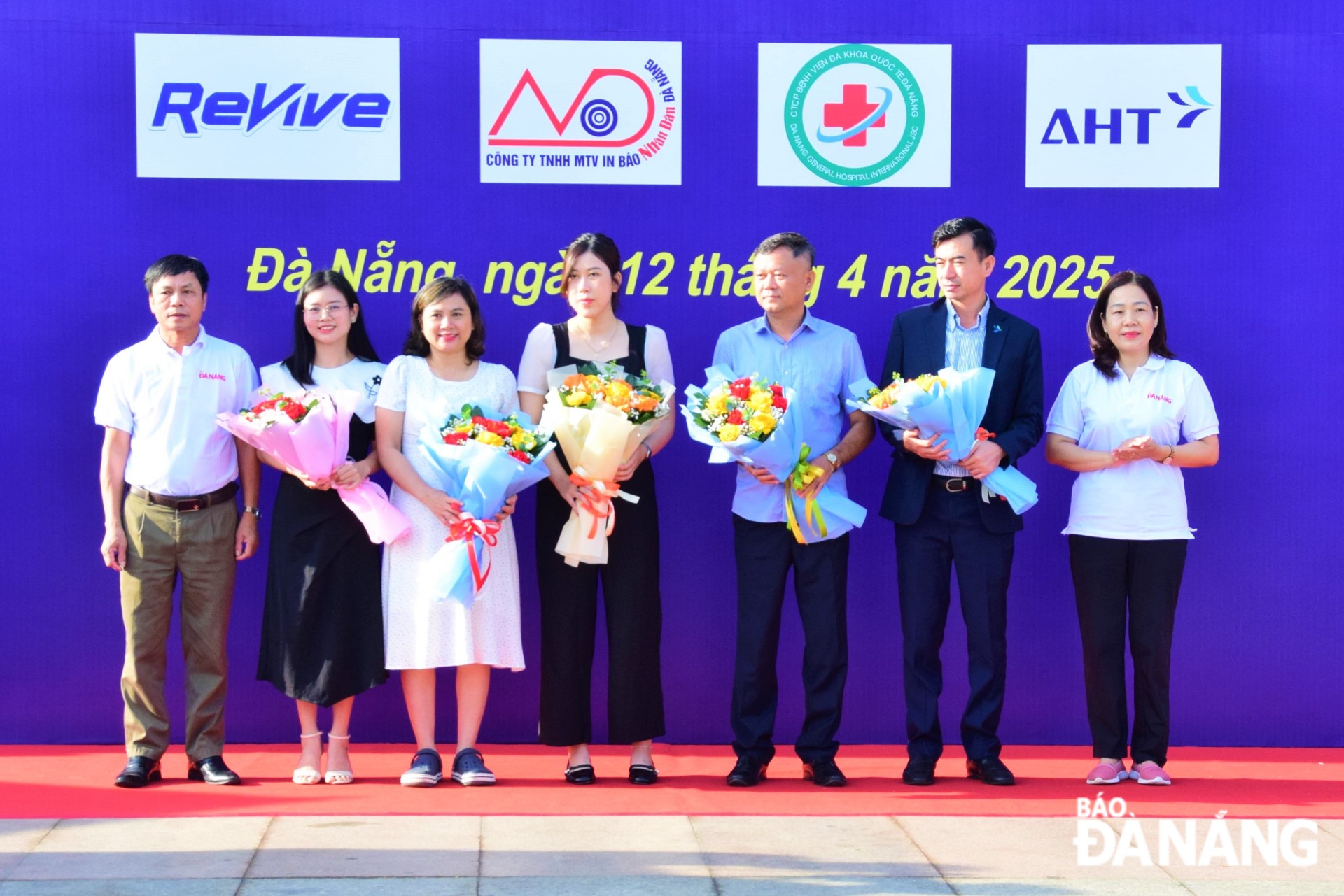 Phó Tổng Biên tập Báo Đà Nẵng Trần Thị Thu Thủy (bên phải), Phó Tổng Biên tập Báo Đà Nẵng Phan Văn Tấn tặng hoa cảm ơn nhà tài trợ. 