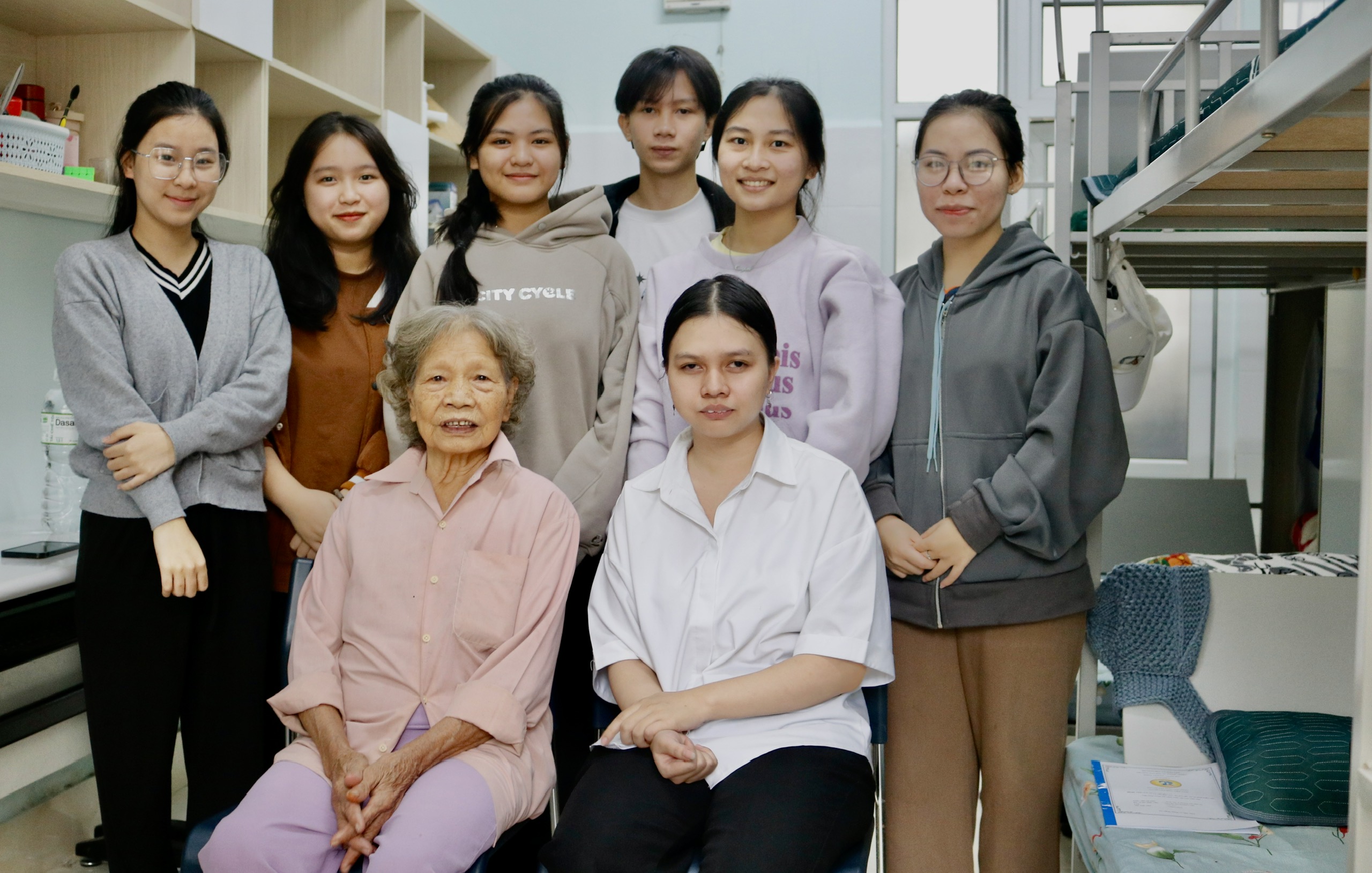 Em Phạm Nguyễn Thanh Lam (hàng trước, đầu tiên từ phải qua) cùng bà ngoại sống trong căn phòng ở ký túc xá Trường Đại học Sư phạm, Đại học Đà Nẵng. Căn phòng được nhà trường miễn phí tiền thuê. Ảnh: T.D