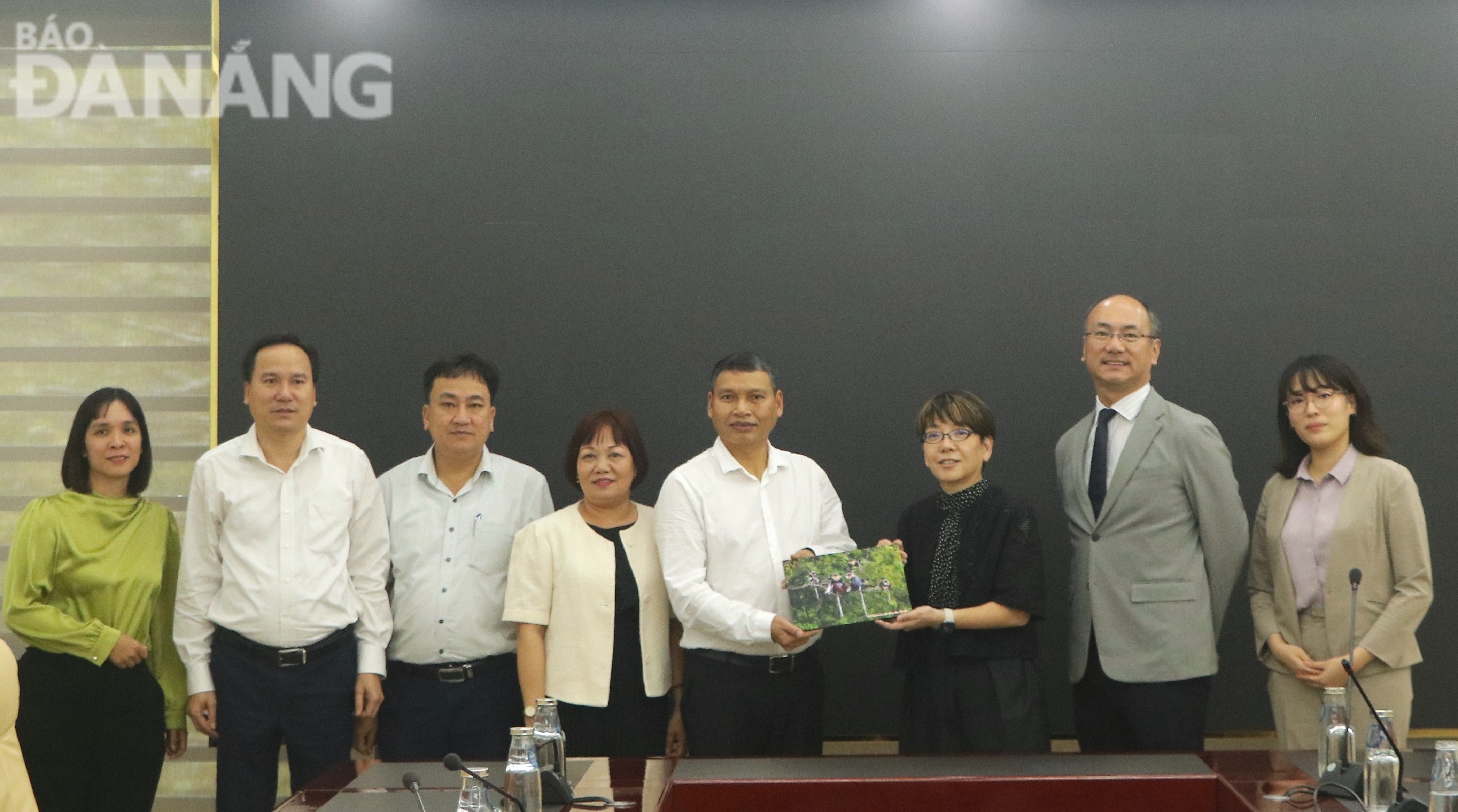 Phó Chủ tịch Thường trực UBND thành phố Hồ Kỳ Minh (thứ 5, trái qua) tặng quà lưu niệm cho đại diện Ngân hàng JBIC. Ảnh: M.QUẾ
